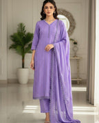 Woman wearing a purple traditional outfit with a matching dupatta in an indoor setting.